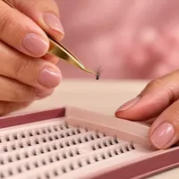 Pinça dourada segurando um tufinho de cílio fino